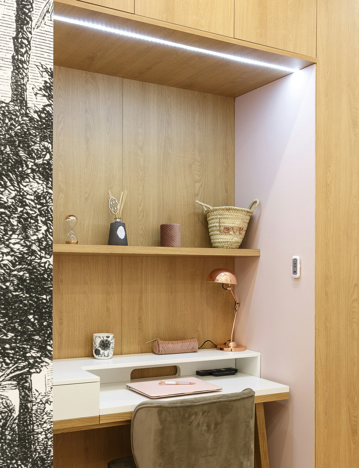 Bureau dans une chambre d'adolescente aux murs roses et au papier peint noir et blanc