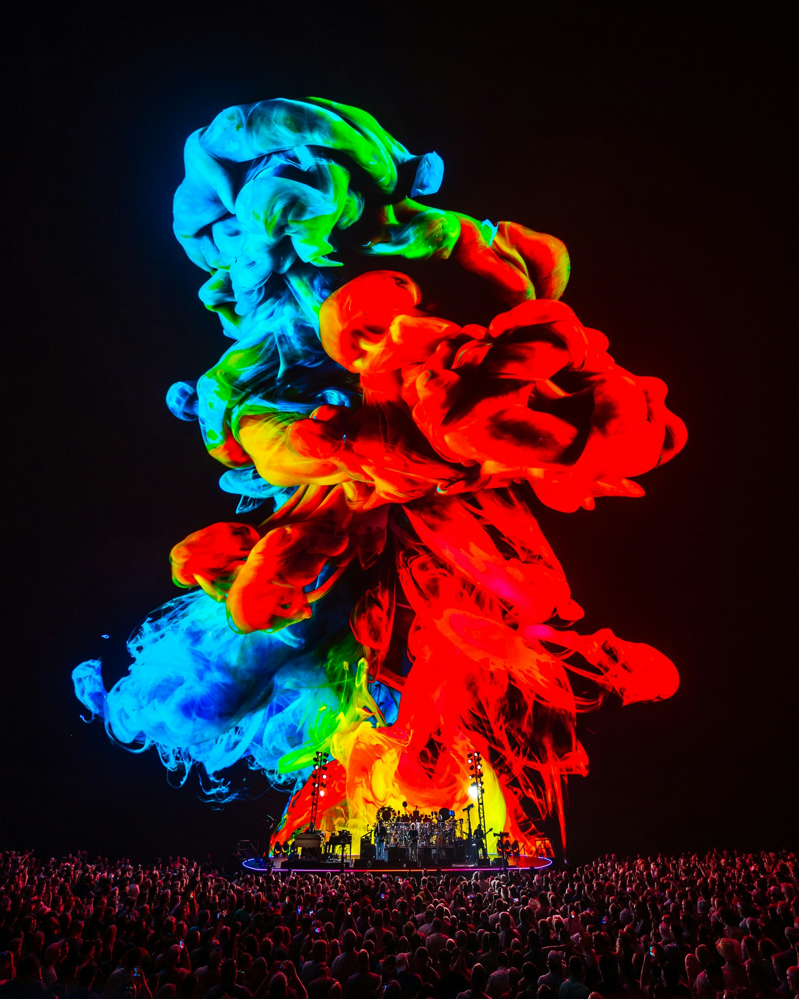 dead and company at sphere, a large colourful plume of smoke billows over the crowd