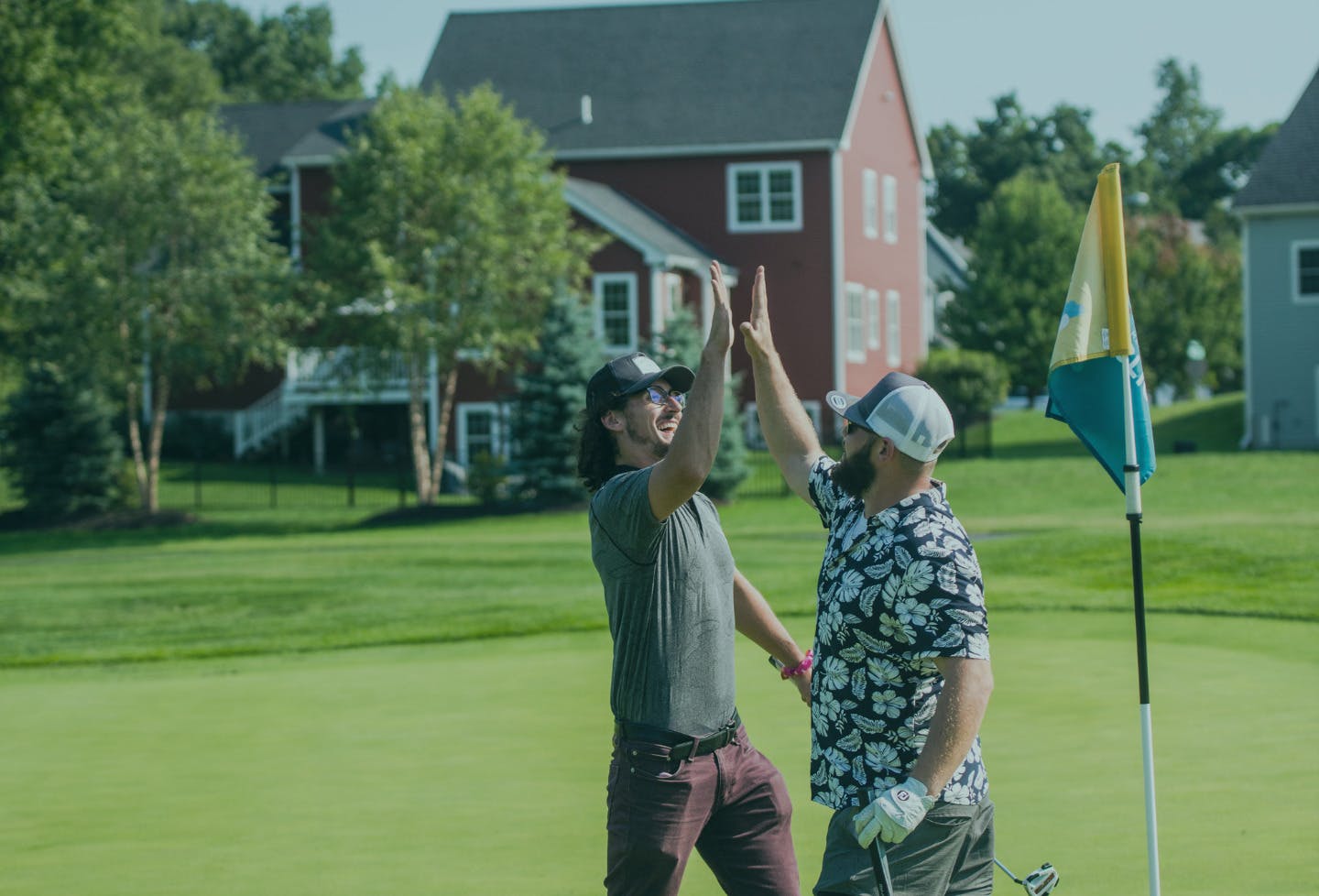 Two people high five on a golf course