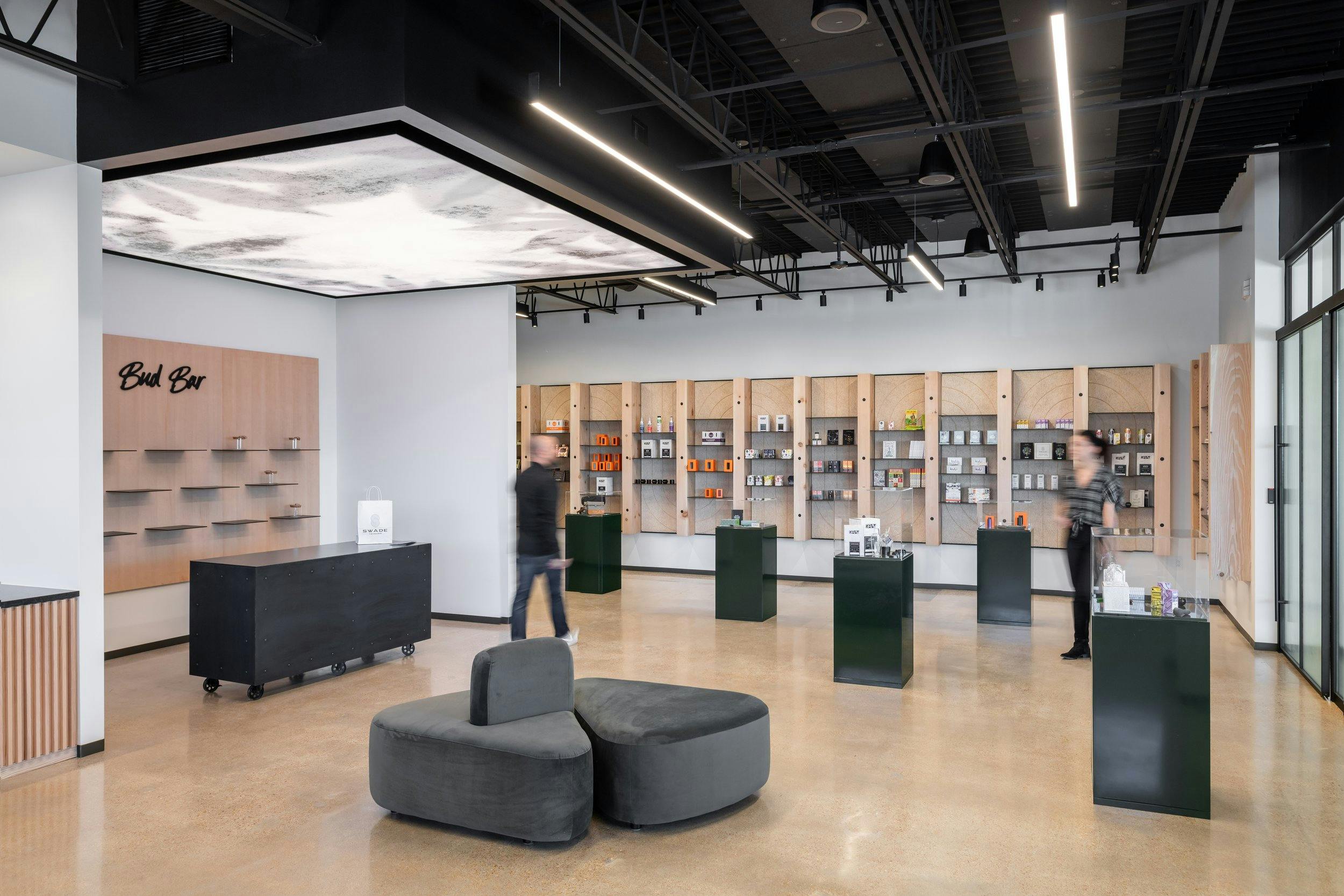 An architectural rendering of the interior of a modern dispensary - the shelves are full of cannabis products and there is comfortable waiting seating