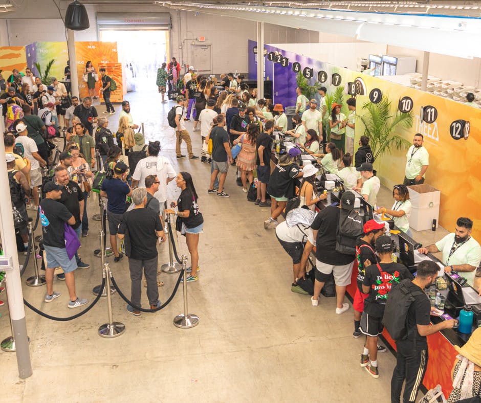 A brightly colored temporary dispensary floor packed with Hall of Flowers conference goers