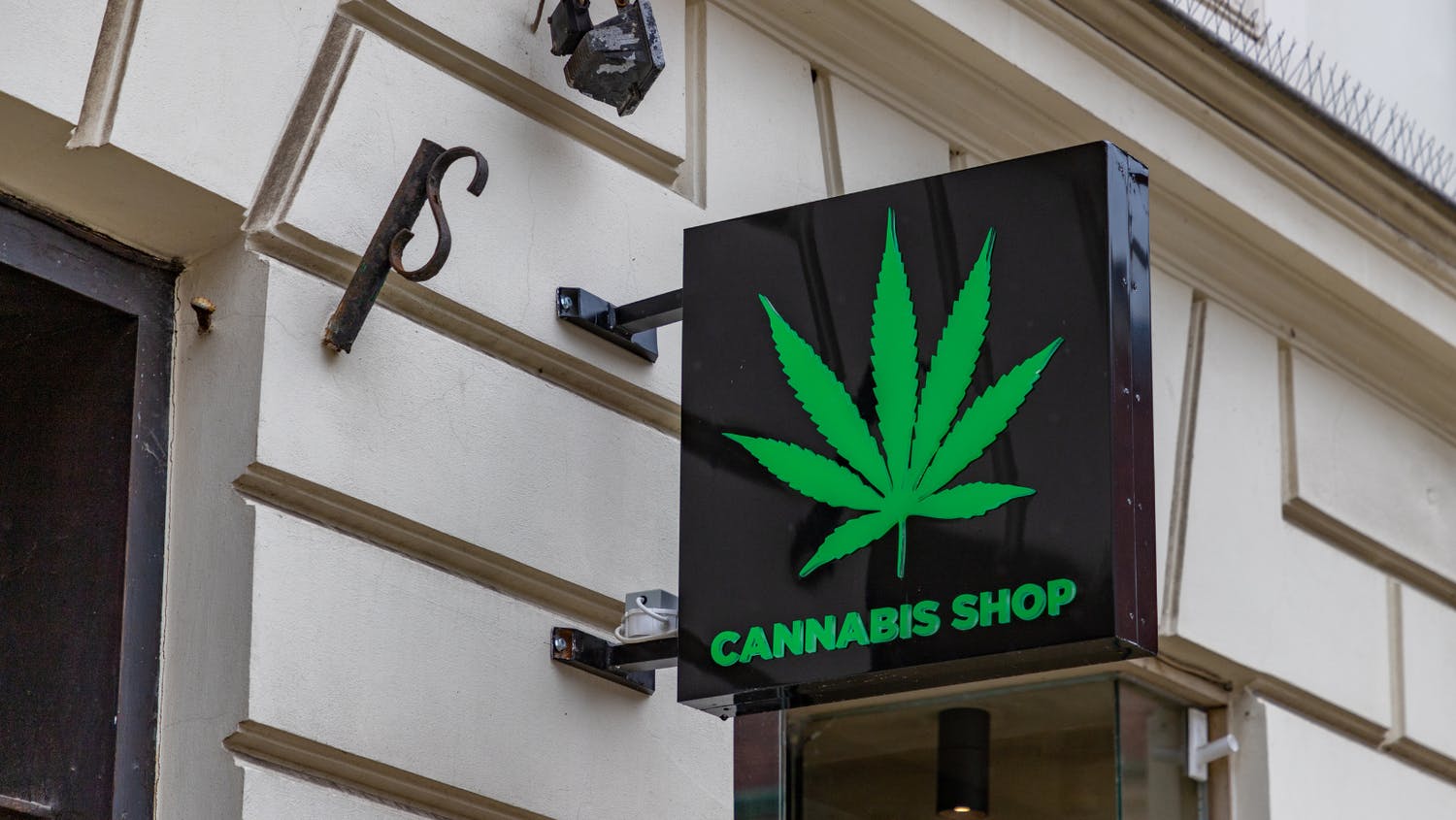 A sleek storefront is shown, close up on the sign with a cannabis leaf and the words Cannabis Shop 