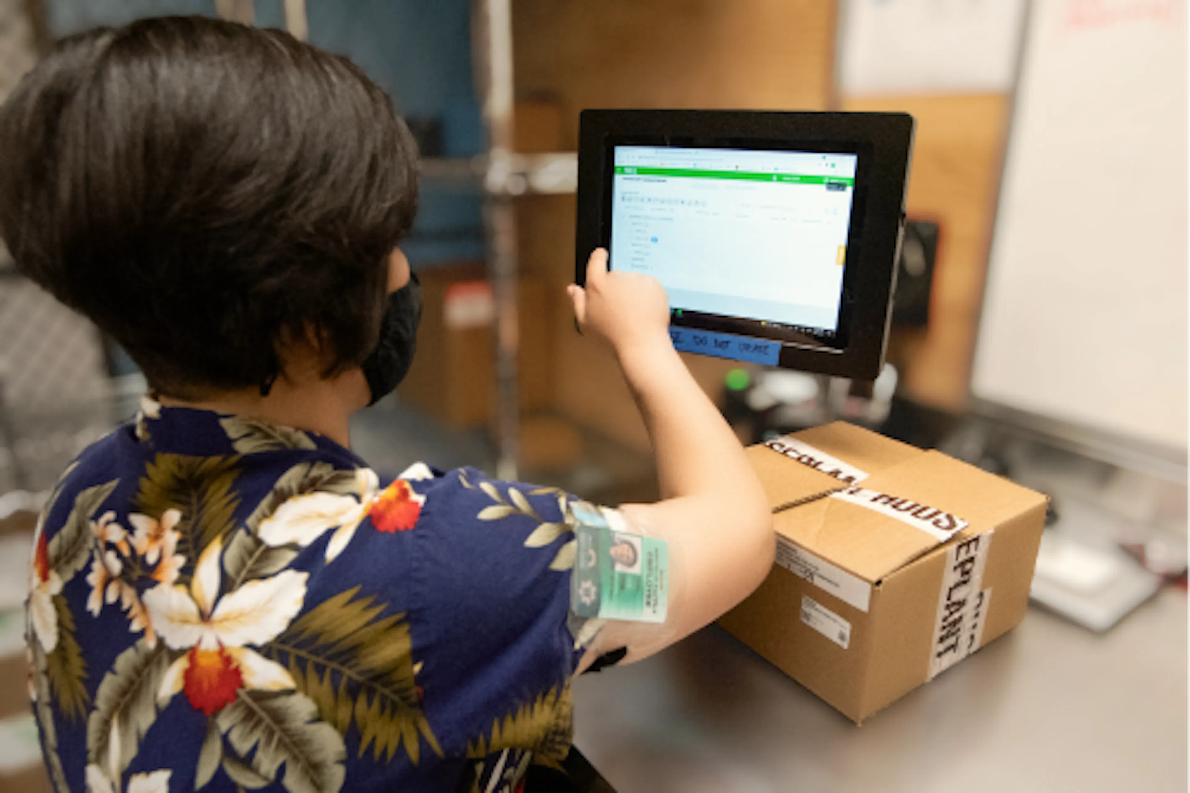 A worker unpacks an order and performs inventory management in the back room of a cannabis dispensary