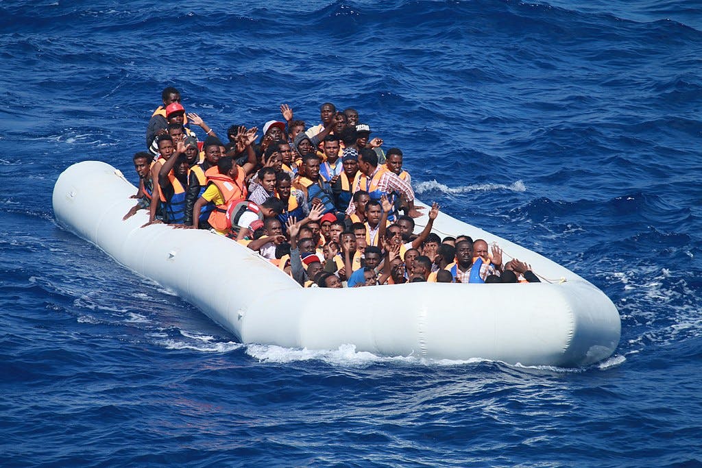 Migrants aboard an inflatable vessel approach the guided-missile destroyer USS Carney, © Commander, U.S. Naval Forces Europe-Africa/U.S. 6th Fleet