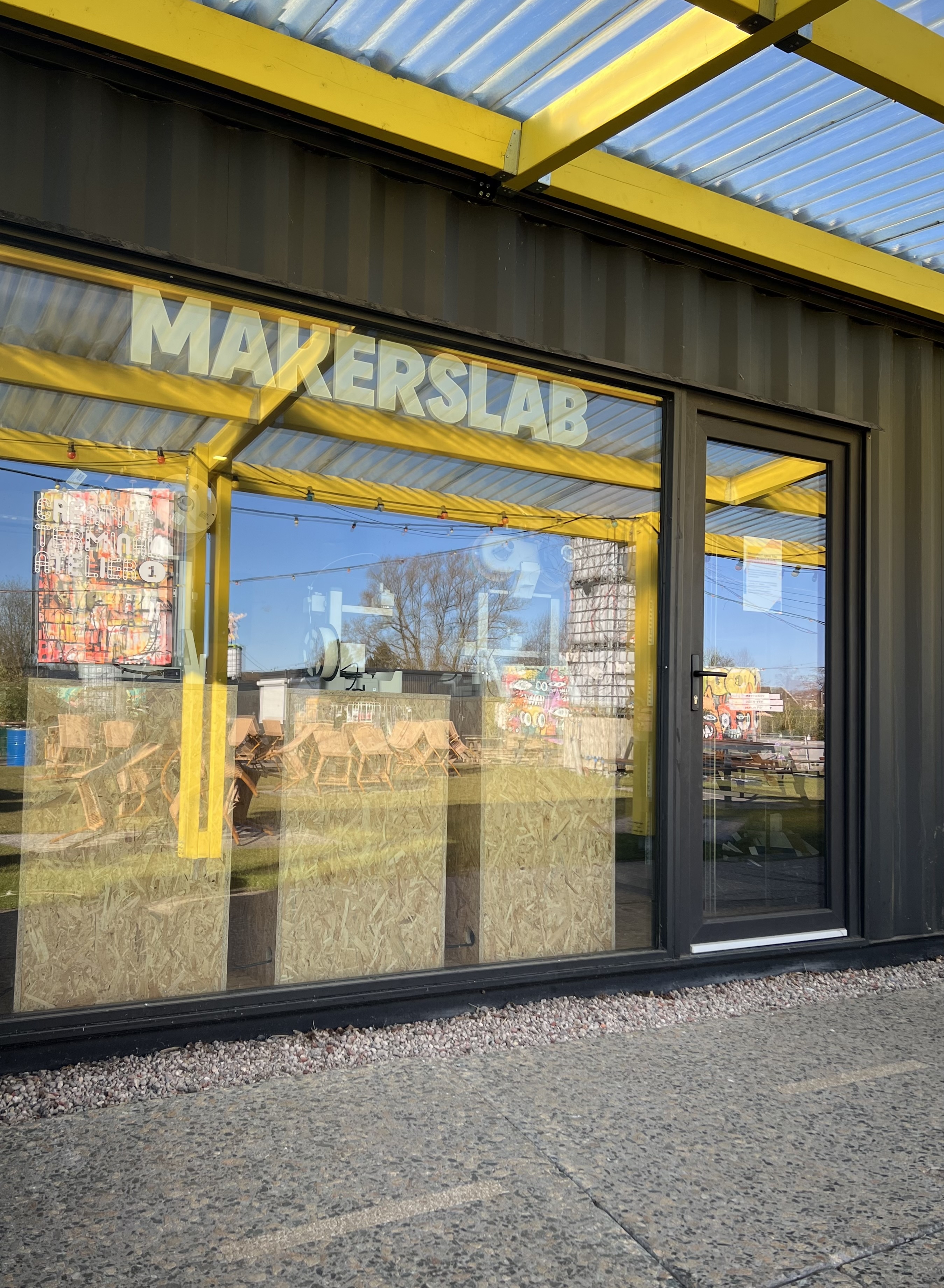 omgebouwde zeecontainer met glazen ruit waar de letters makerslab op staan