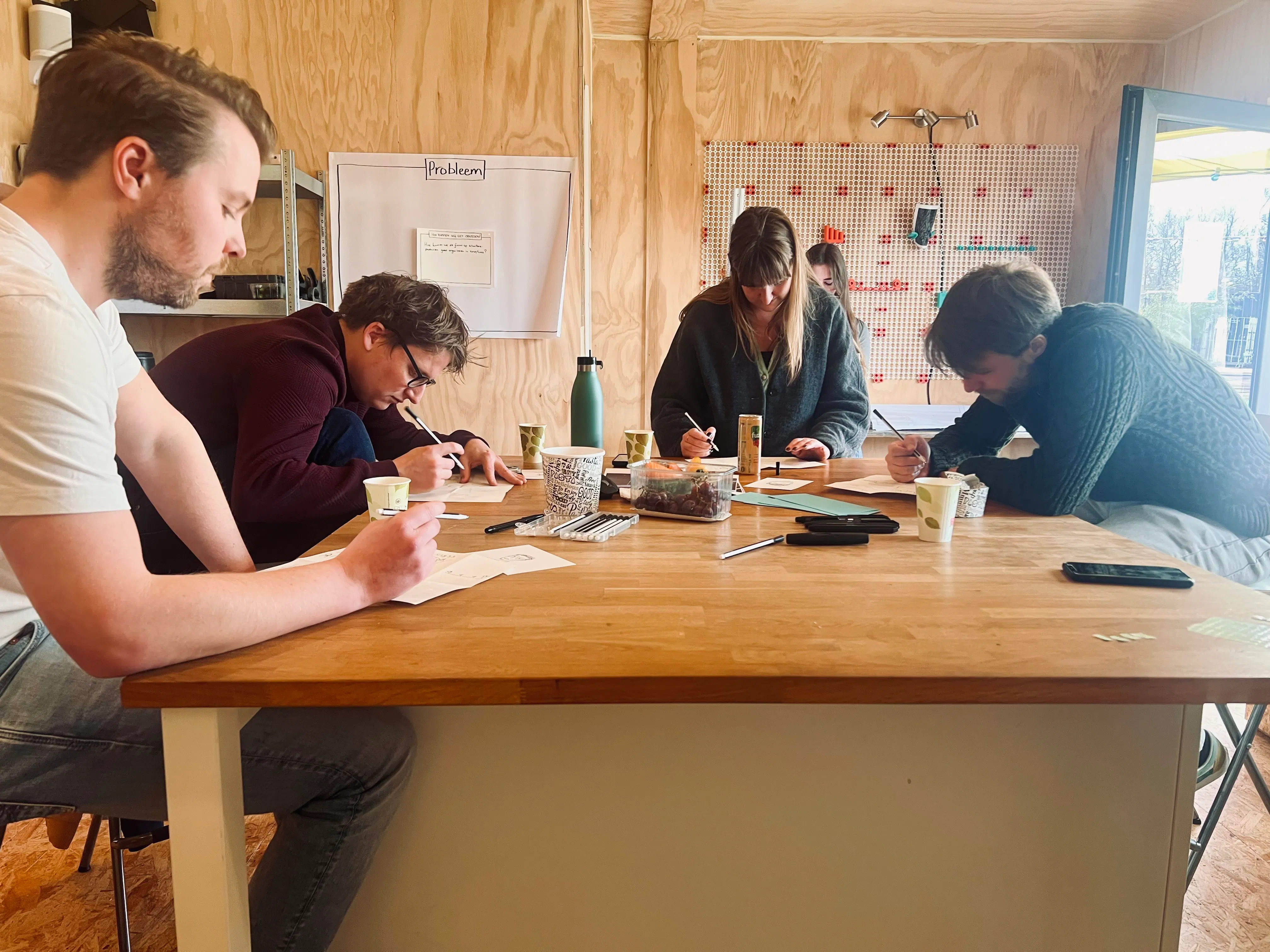 verschillende mensen werken samen aan een hoge tafel