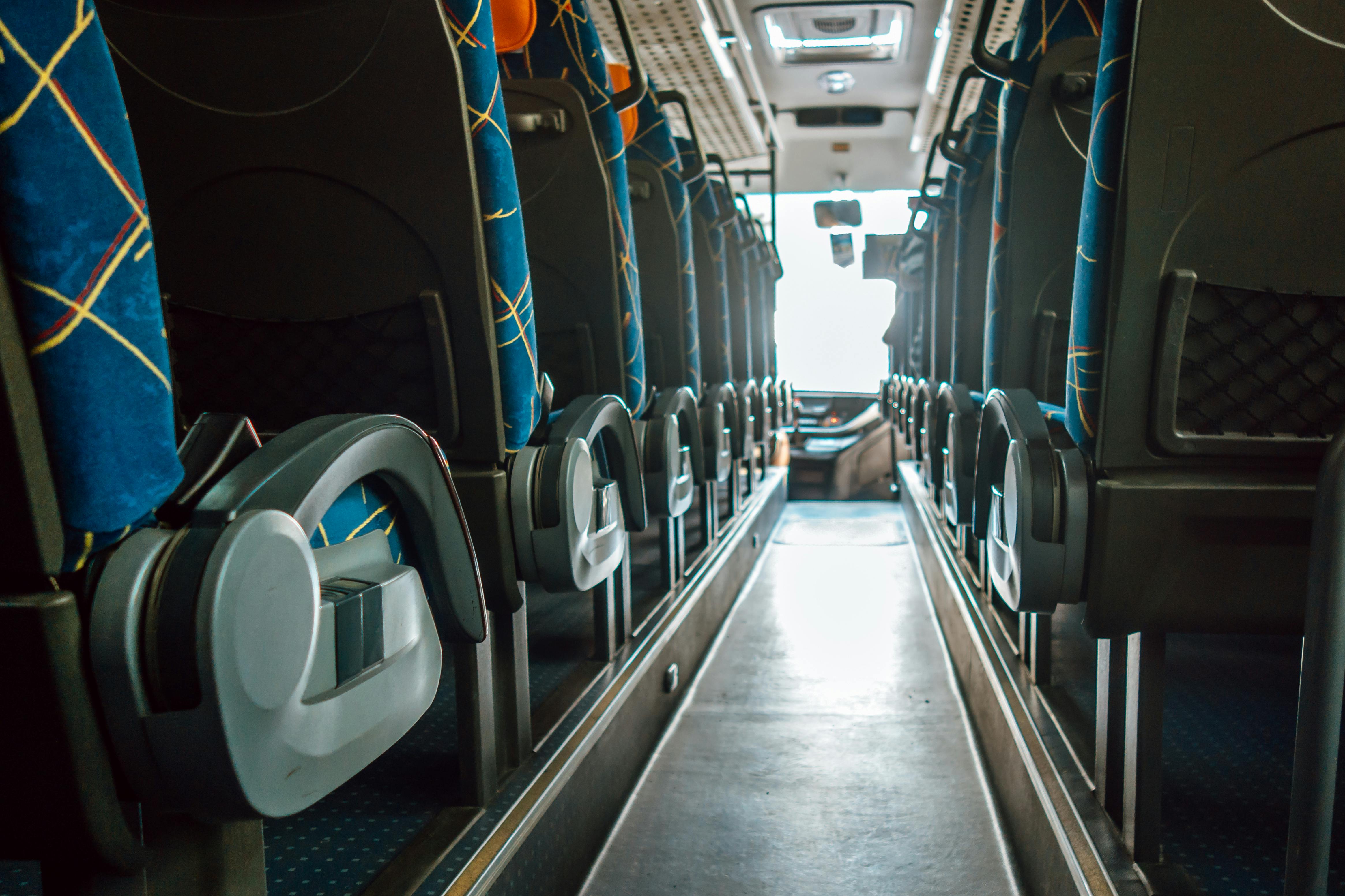 Empty bus interior with rows of passenger seats and aisle