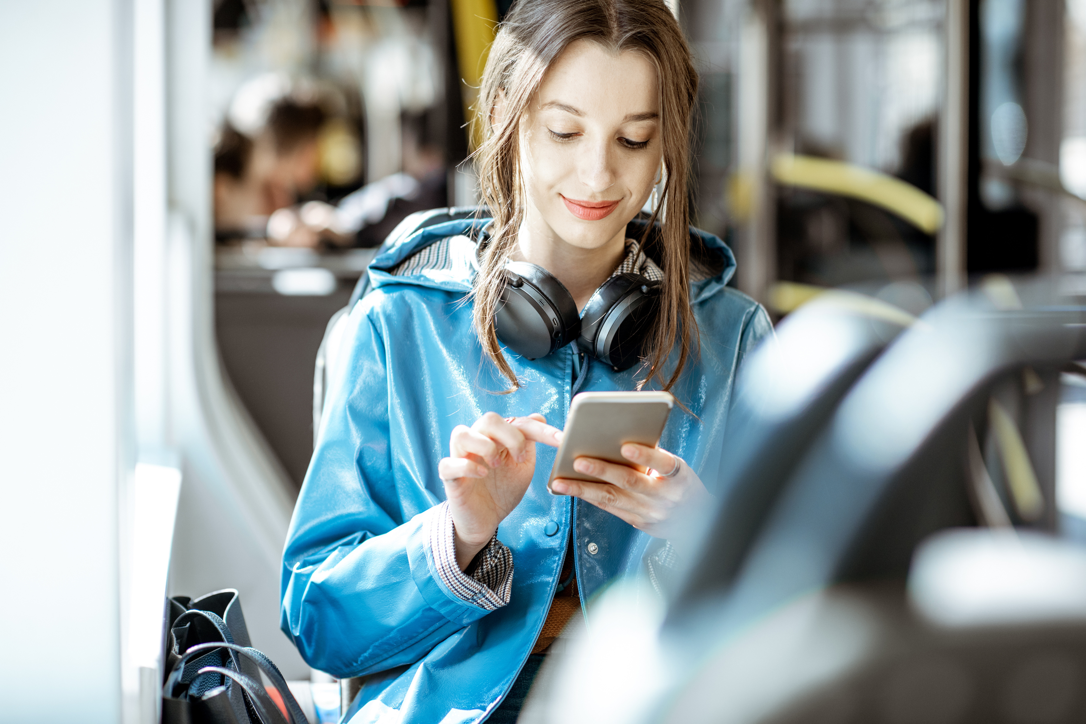 Woman using smartphone while riding public transit bus