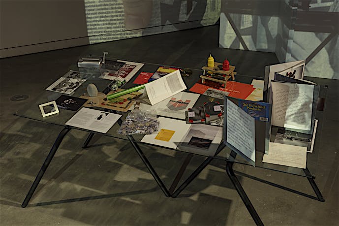 Installation detail of table, video and 35mm slide projection Finding Chopin: Dans l’Essex, 2014, at Tris Vonna-Michell exhibition, VOX – Centre de l’image contemporaine, Montreal. February until April 2014