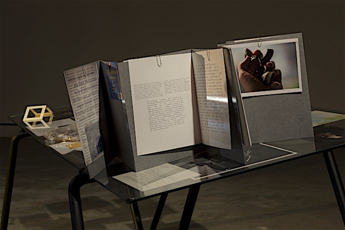 Installation detail of table, video and 35mm slide projection Finding Chopin: Dans l’Essex, 2014, at Tris Vonna-Michell exhibition, VOX – Centre de l’image contemporaine, Montreal. February until April 2014