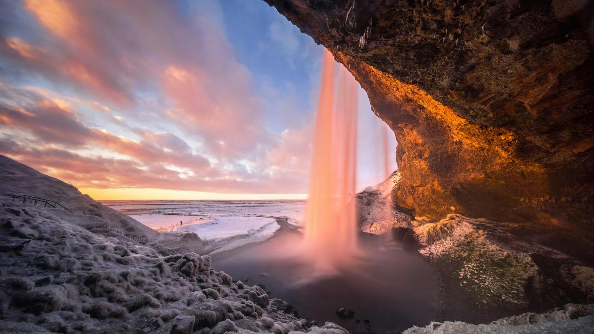 Photo of a waterfall during a sunset in winter time.