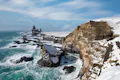 Coastline with basalts cliffs covered with snow.