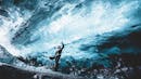 Person inside an ice cave, the person is touching on the ice cave ceiling.