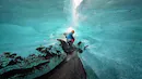 Person crouching between two large chunks of ice.
