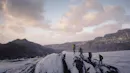 Four-person hiking up an ice hill on a glacier.