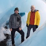 Two men inside an ice cave.