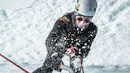 Woman smashing her ice axe on the ice while small pieces of ice are exploding.