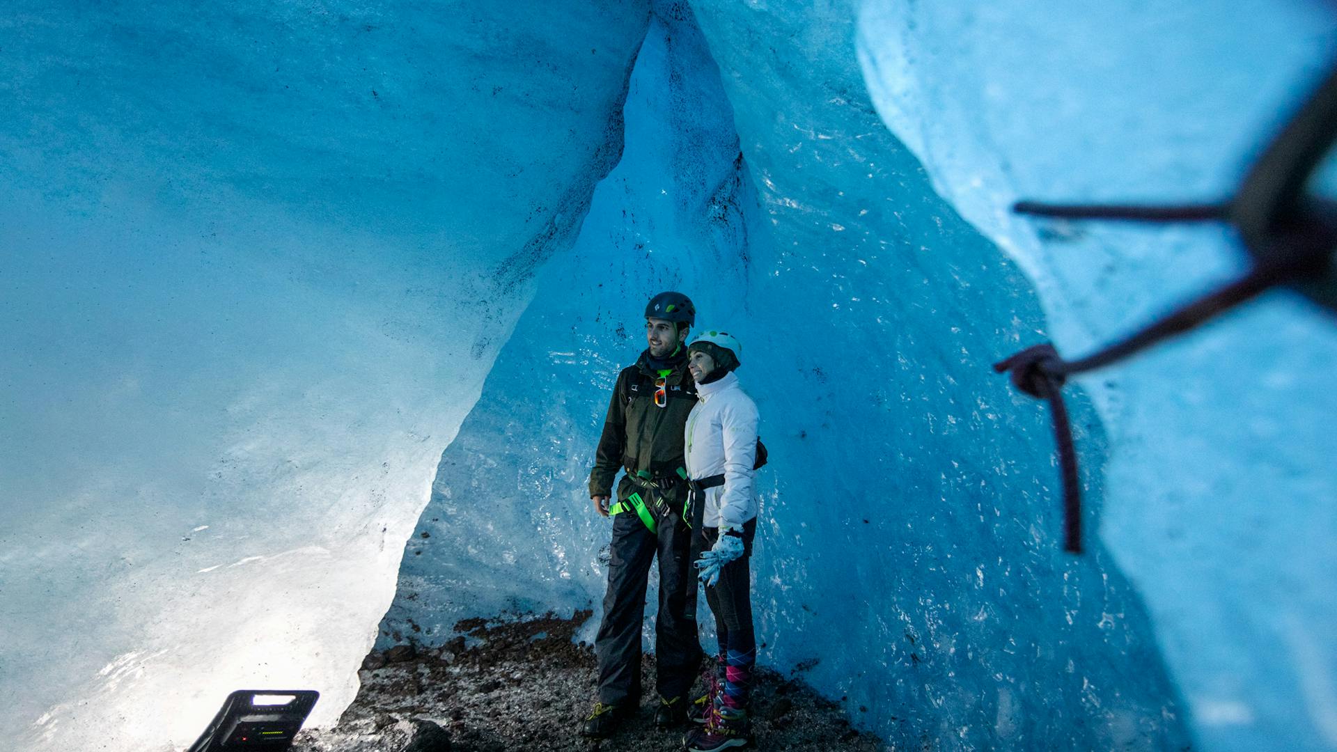 A couple holds each other while they are getting photographed inside an ice cave.