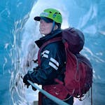 woman smiling at the camera while she's inside an ice cave.