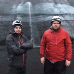 Two mens wearing a helmet with a glacier on the back.