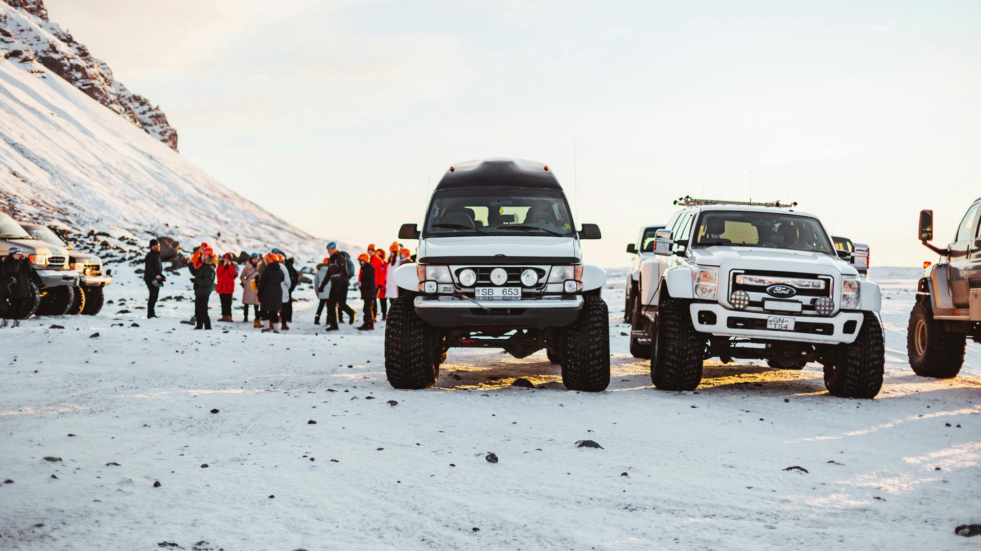 Modified cars parked in the middle of the snow.