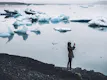 A person taking photos with a mobile of a glacier Lagoon.