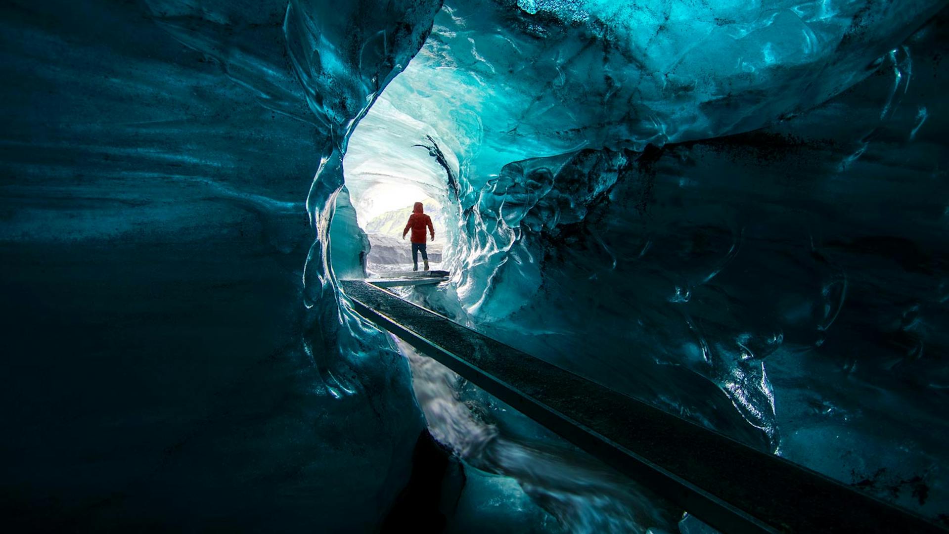 Person looking at the exit of an ice canyon.