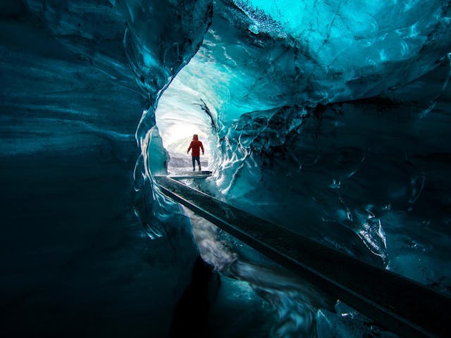 Person looking at the exit of an ice canyon.