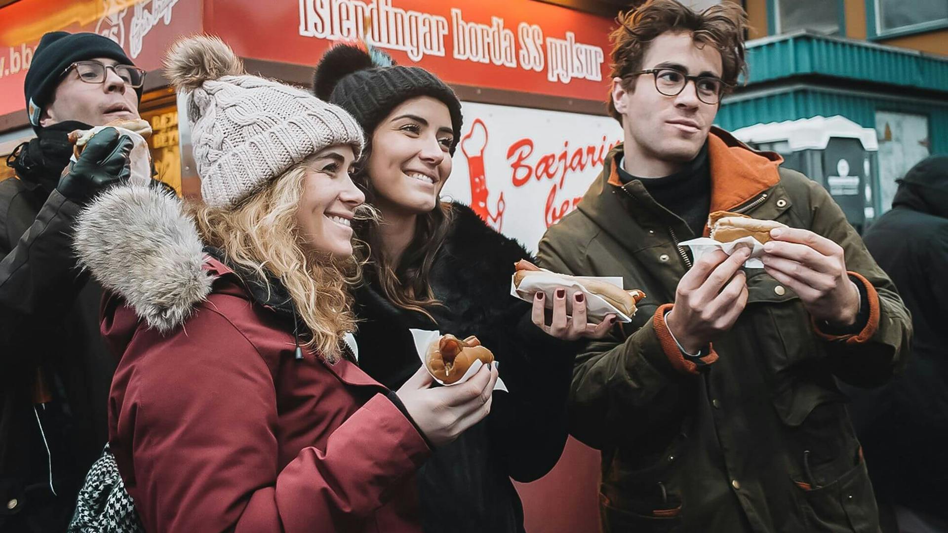Happy people eating Icelandic Hot dogs