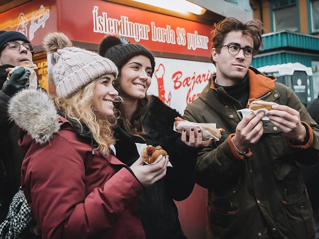 Happy people eating Icelandic Hot dogs