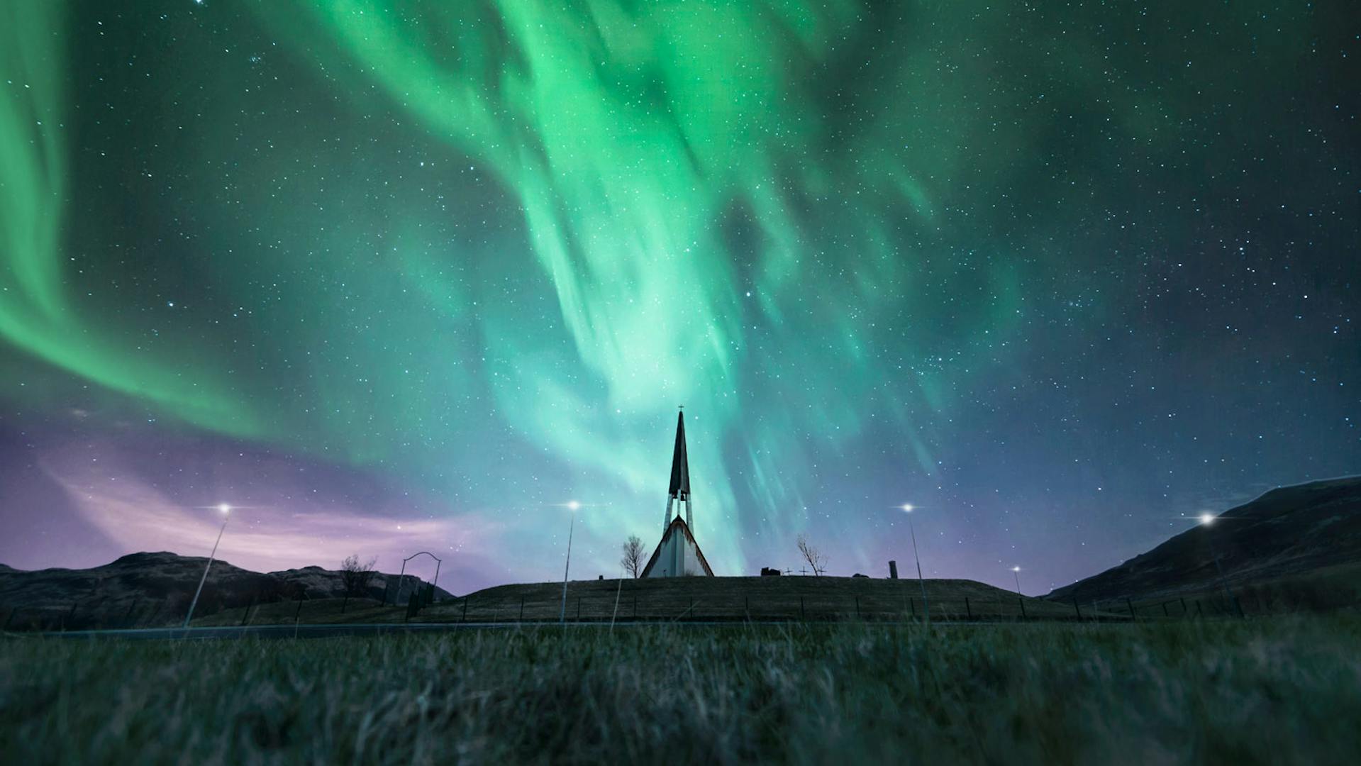 Spiky church photographed under northern lights.