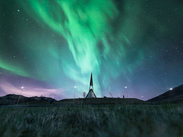 Spiky church photographed under northern lights.