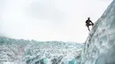 Man ice climbing a glacier near the ice falls