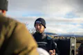 A guide wearing a beanie gives instructions to his clients.