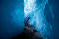A person taking photos with a mobile inside an ice cave.