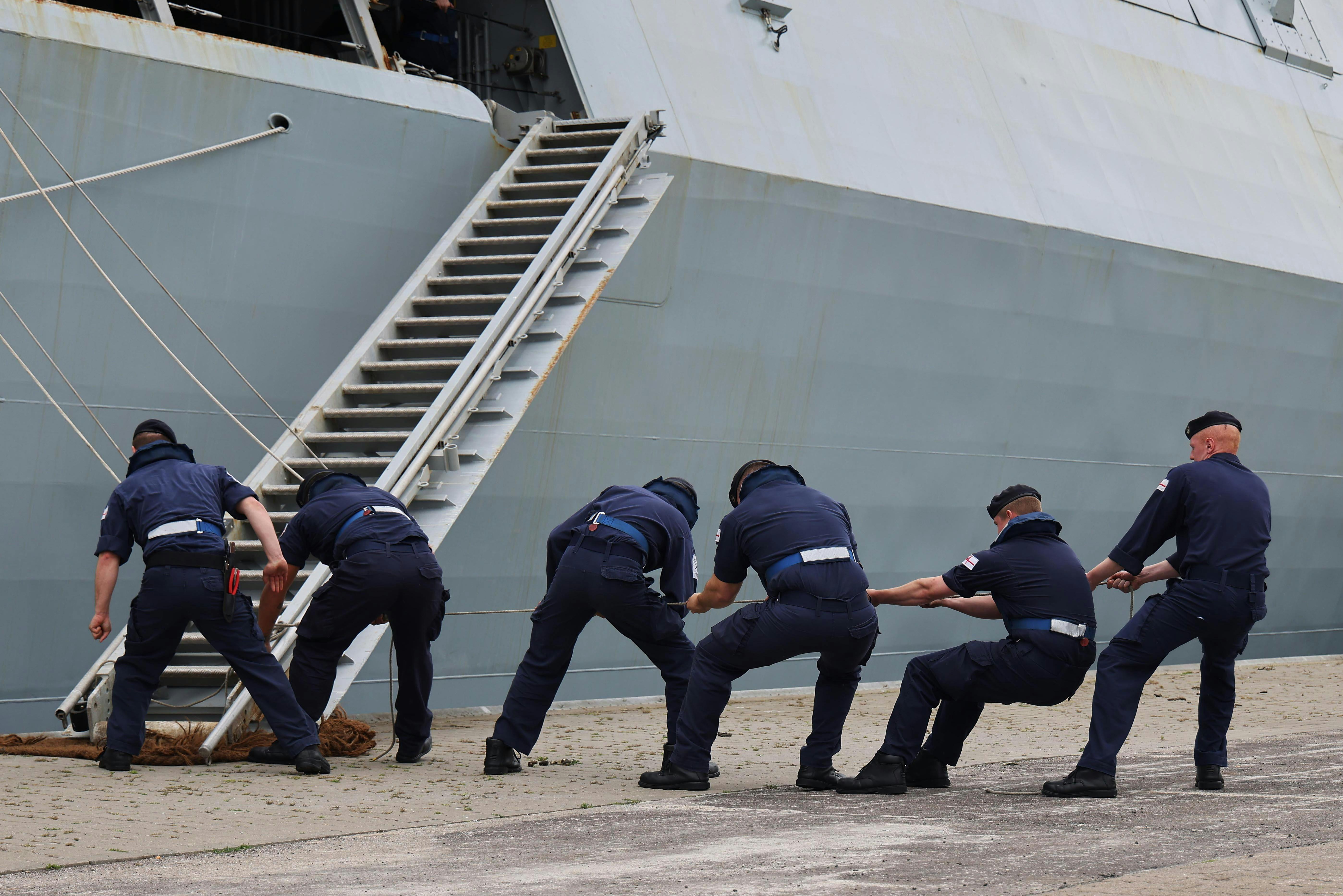 Sailors pulling on rigging