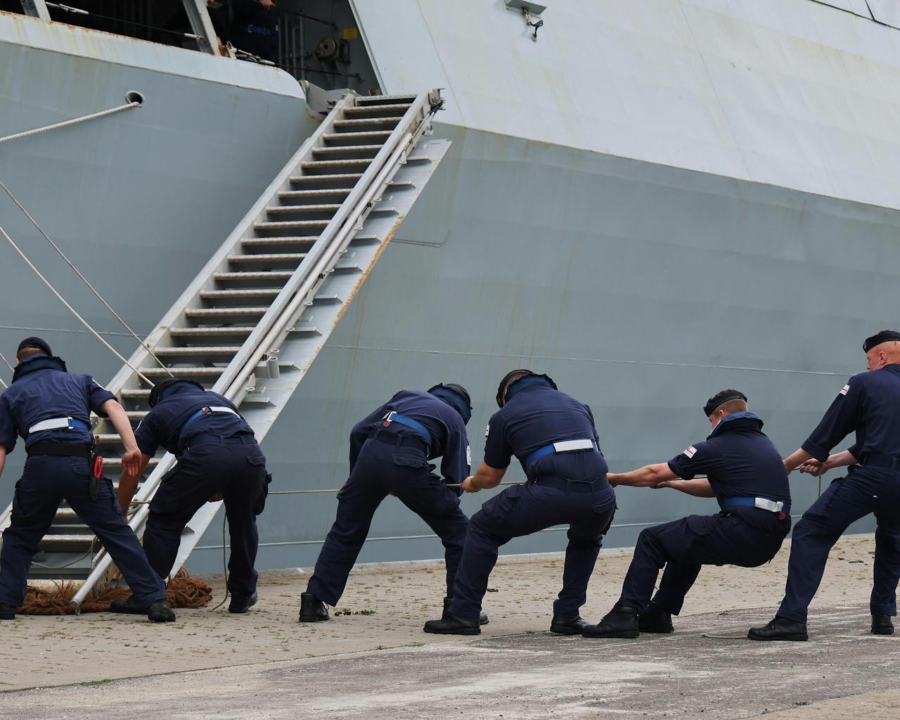 Sailors pulling on rigging