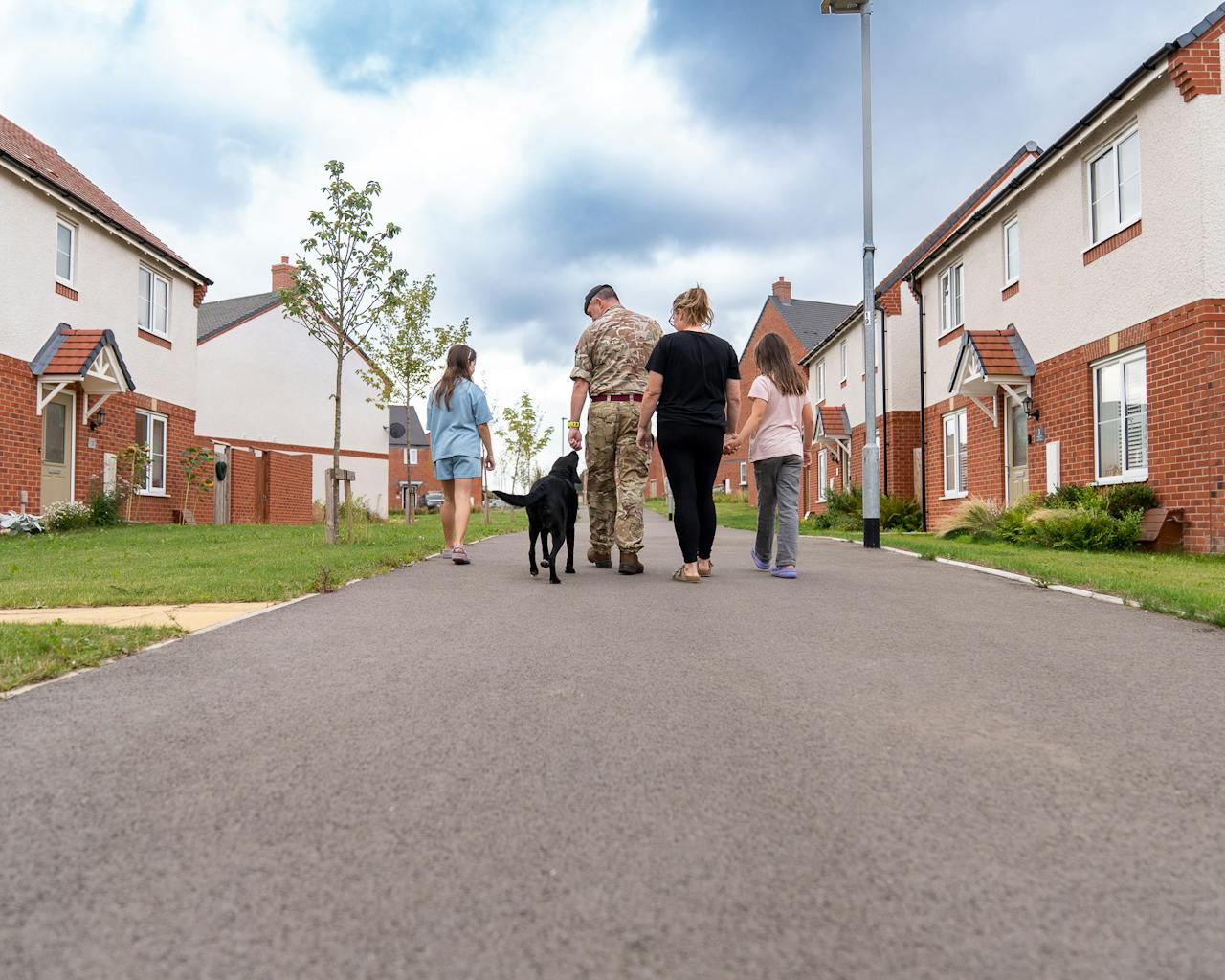 military family with dog walking down street