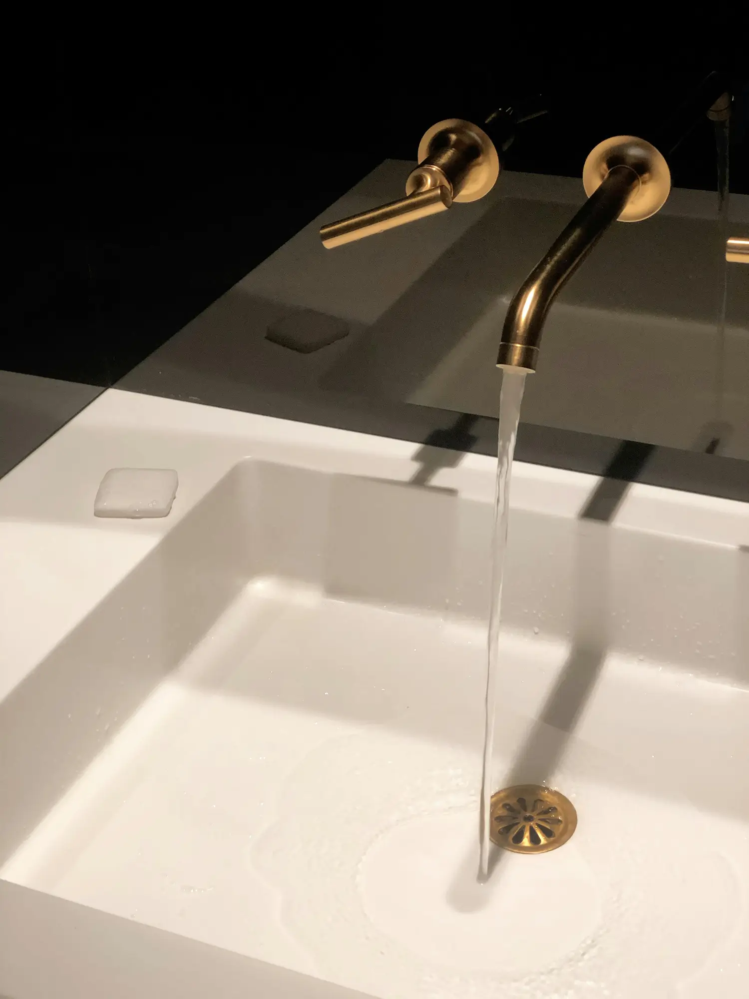 Running water in a white sink with gold-colored faucet and fixtures