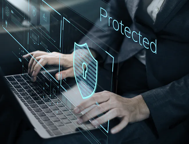 Business person typing on a laptop, with digital graphics overlayed.