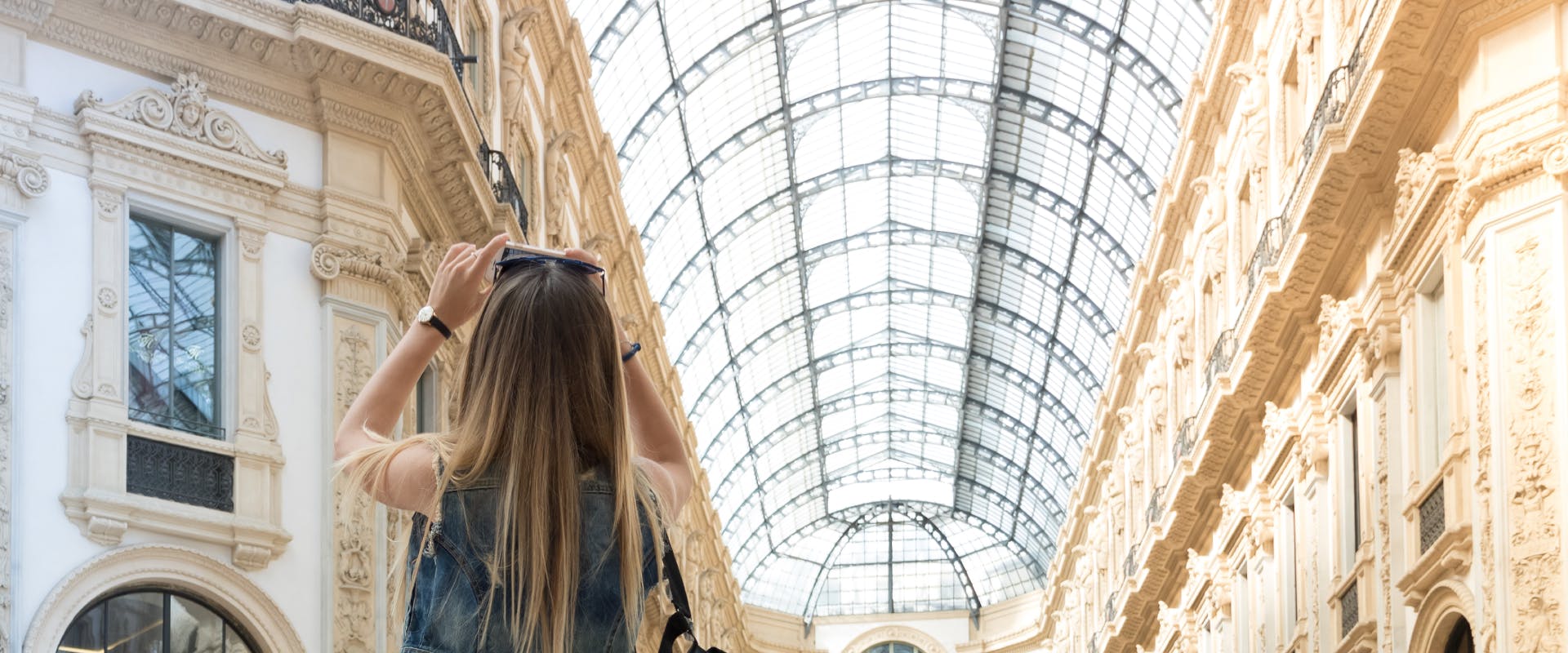 A woman photographing the ceiling of Galleria Vittorio Emanuele II.