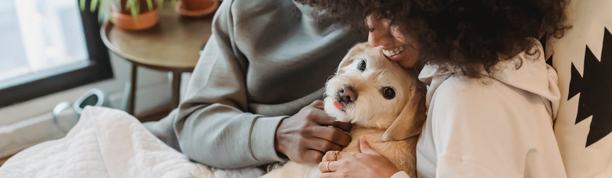 A woman holding a small white dog