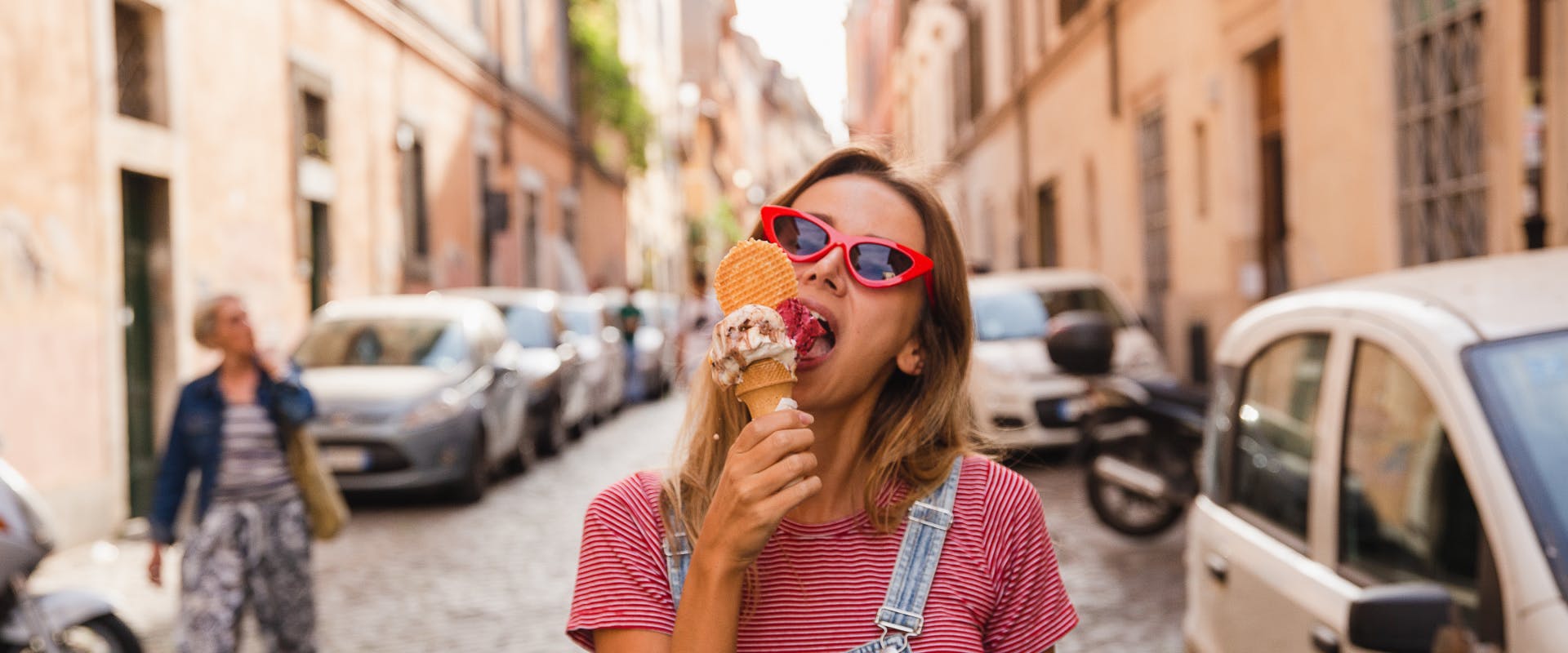 A woman eats a gelato in Rome.