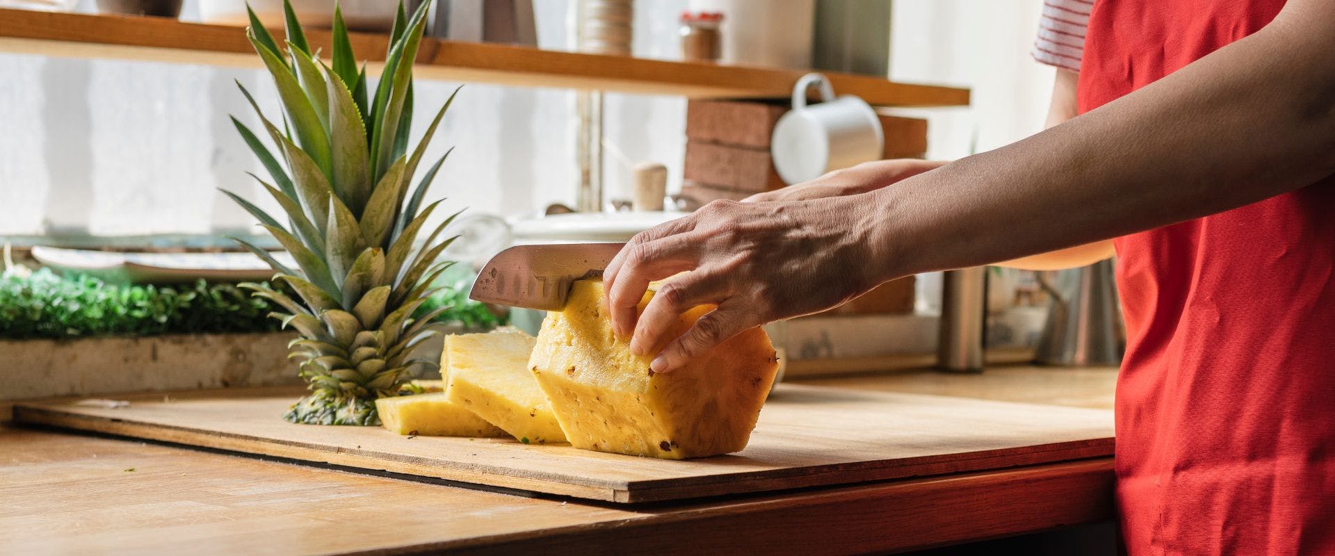 Person slicing a pineapple