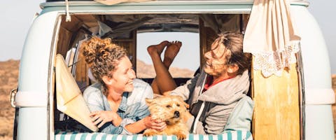 Couple in a van on a road trip with a dog