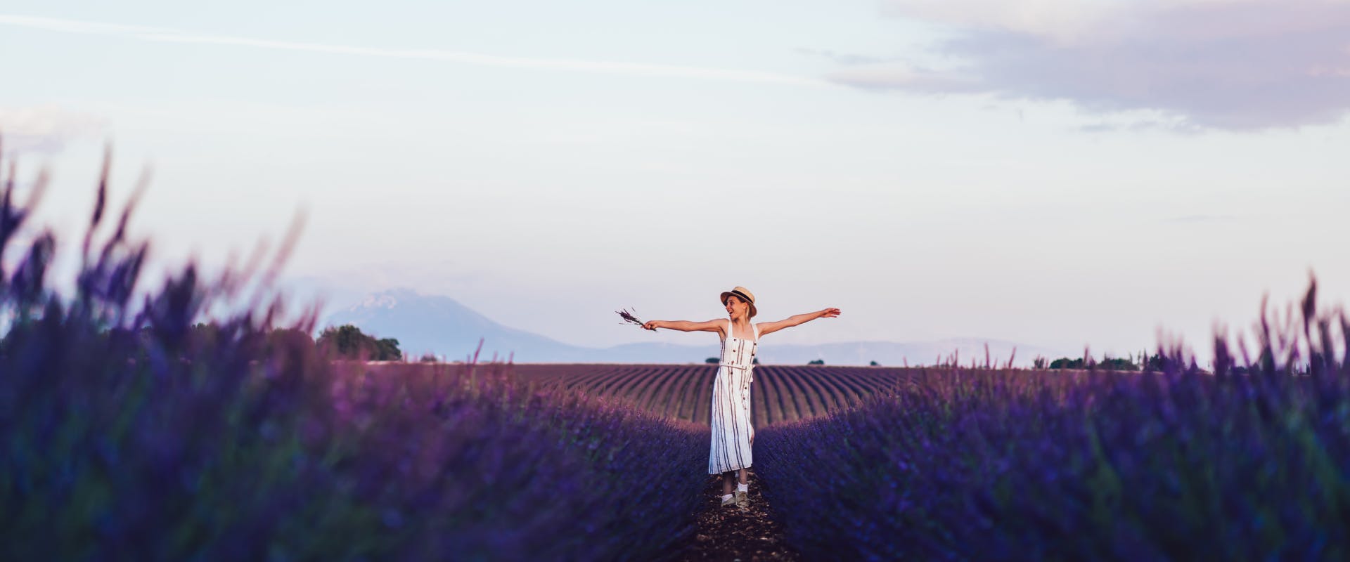 a solo female traveler in France standing in a lavender field