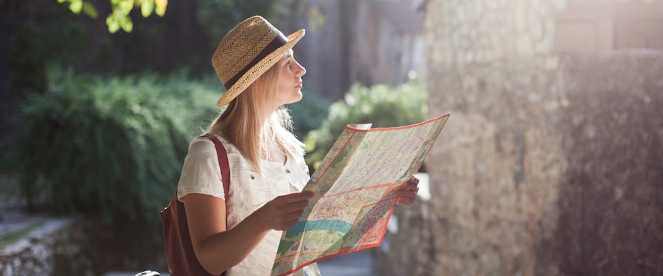 solo female traveler looking at a map whilst exploring