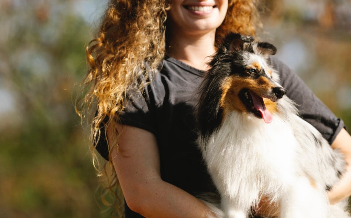 Person cuddling a dog