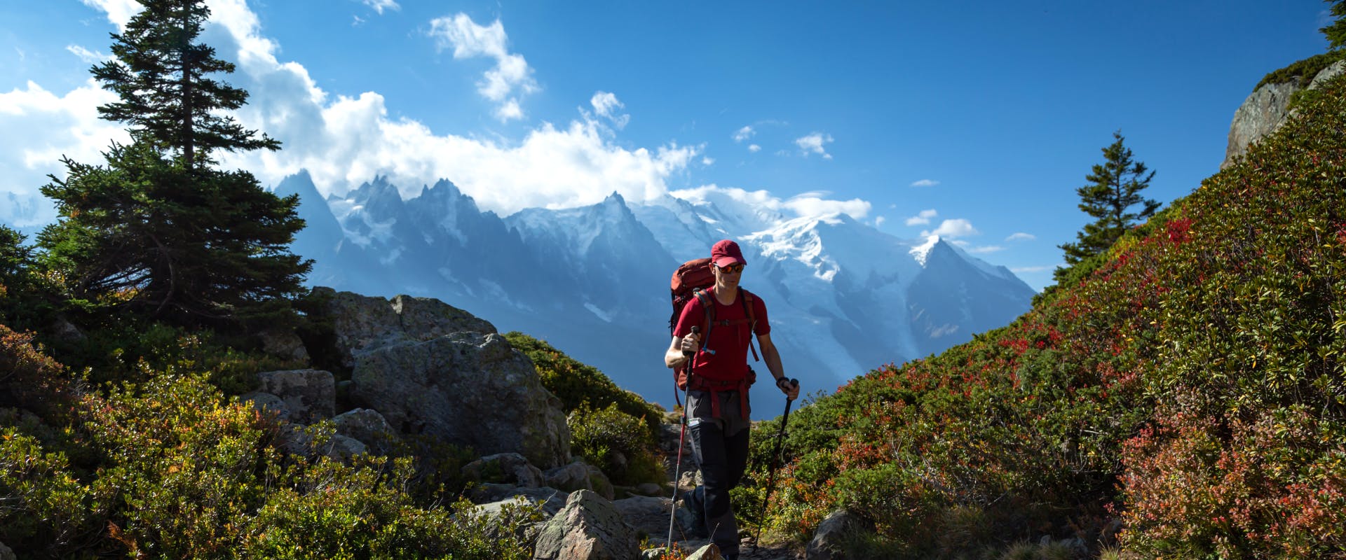 a solo female traveler walking towards the camera whilst on a hike in The Alps