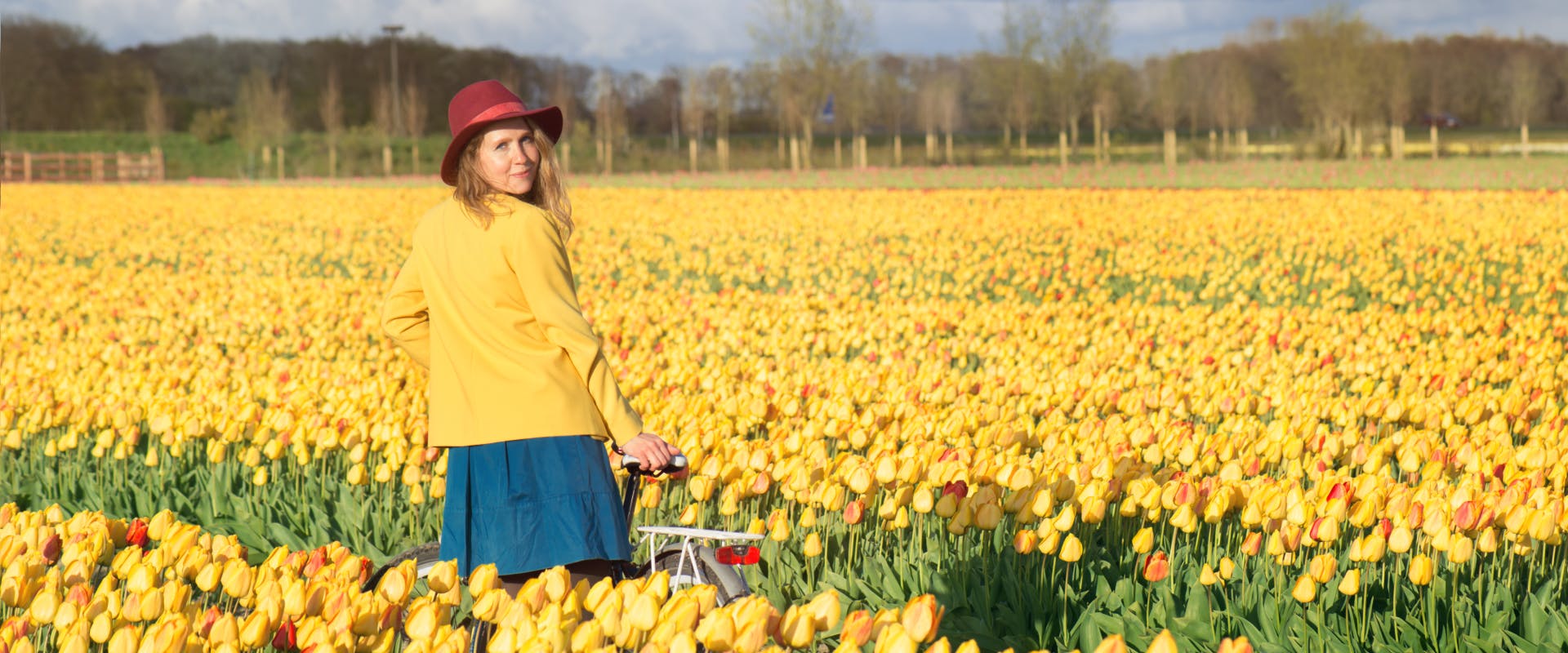 A woman standing in a field of tulips.